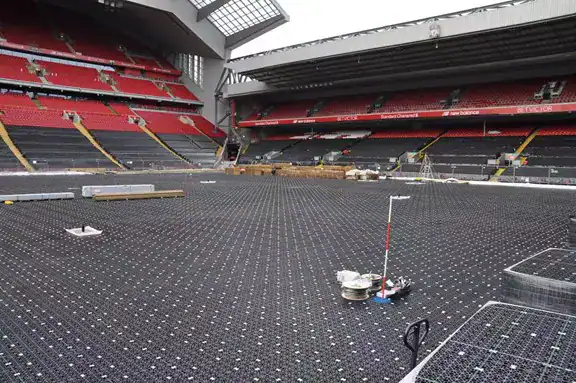 Полномасштабная установка неглубокой геоячеистой системы отвода ливневых вод под полем стадиона для быстрого дренажа и поддержки нагрузки.