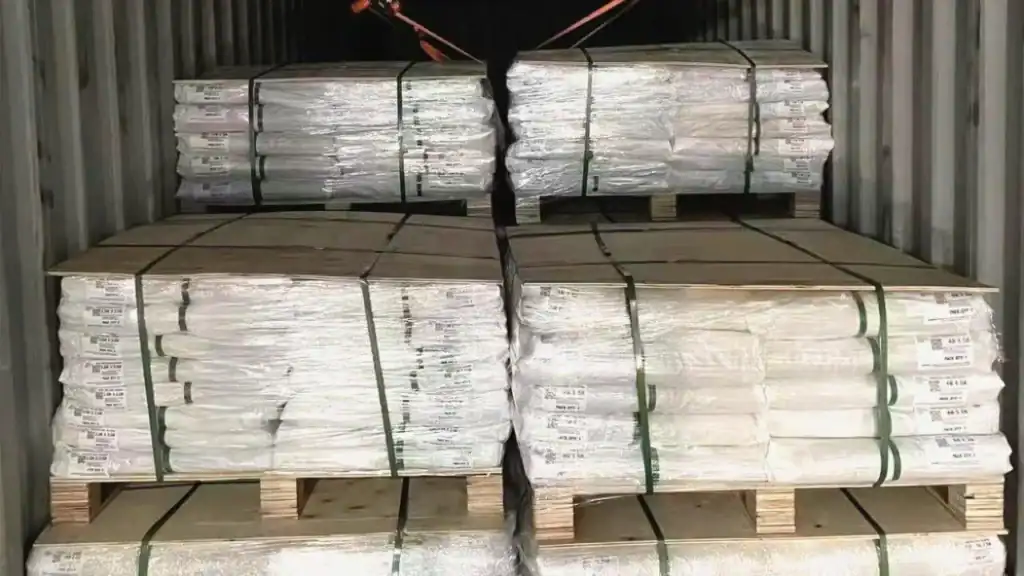 Rollos de revestimiento de caucho EPDM paletizados y asegurados para un transporte internacional seguro.
