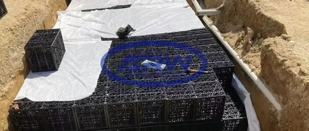 Ouvrage résidentiel de rétention sur site (OSD) en Australie et en Nouvelle-Zélande : modules alvéolaires de stockage posés sur un géotextile non tissé blanc ; des conduites latérales raccordent l’ouvrage pour la régulation du débit et l’infiltration.