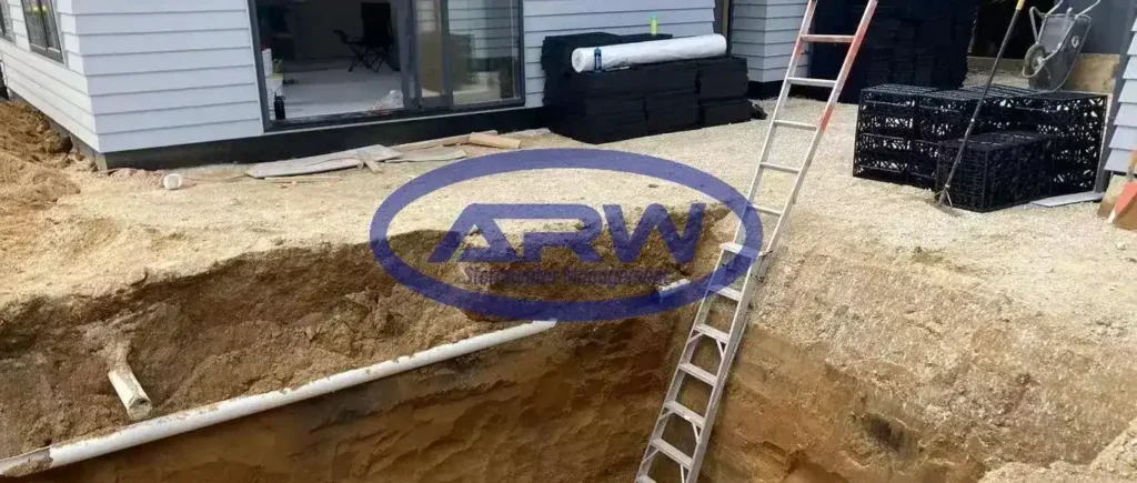 Ouvrage résidentiel de rétention sur site (OSD) en Australie et en Nouvelle-Zélande : modules alvéolaires de stockage empilés et enveloppés dans un géotextile non tissé blanc pour la régulation du débit et l’infiltration.